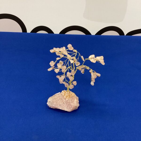 Delicate miniature jade tree sculpture with green stones.