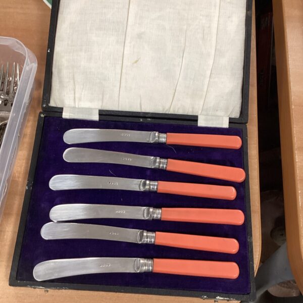 Vintage silverplate butter knives set on a dark surface.