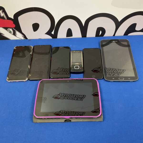 Close-up view of cracked screens on mobile phones in a spares lot.