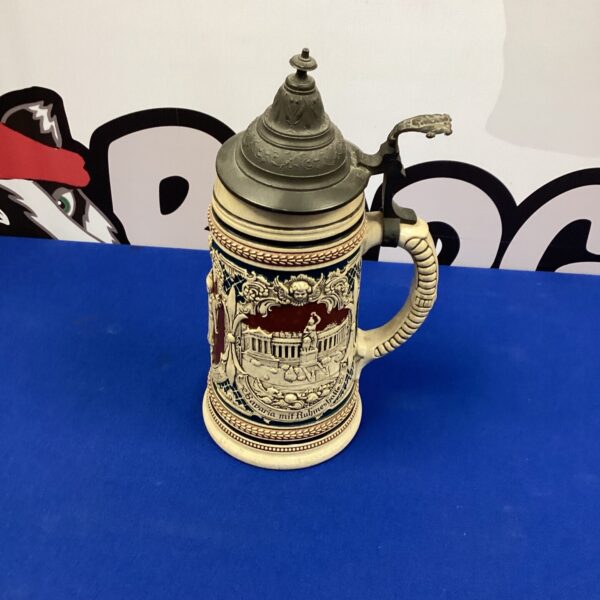 Vintage German beer stein with detailed ceramic relief work.