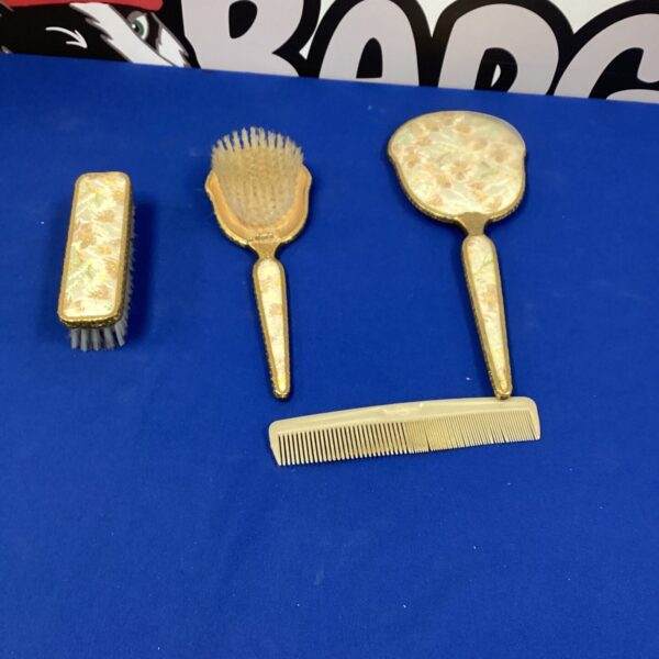 Vintage dressing table set with hand mirror and brush.