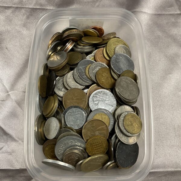 Mixed coin lot in a plastic tub, diverse world currency.