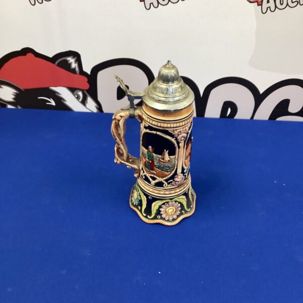 Detailed vintage musical beer stein with a ceramic design.