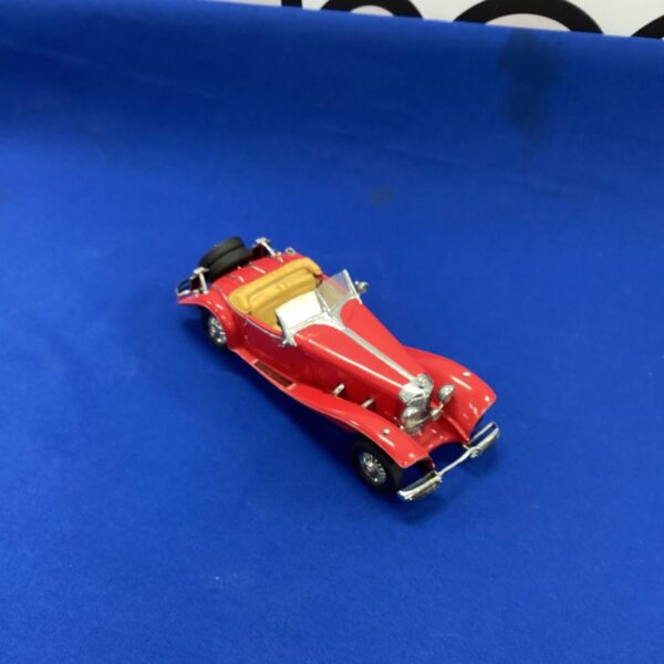 Red diecast Mercedes Benz 500x model car on display.