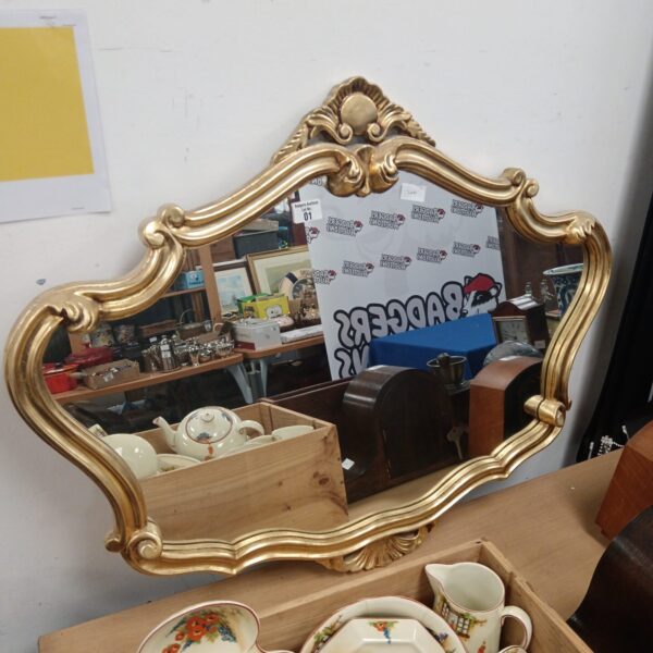 Ornate French style gilt mirror with detailed sculpted frame.