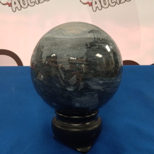 Polished marble globe on a dark stand, decorative stone sphere.