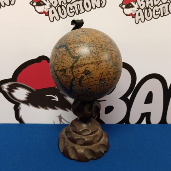 Vintage desktop globe on carved wooden base, detailed geographical map.