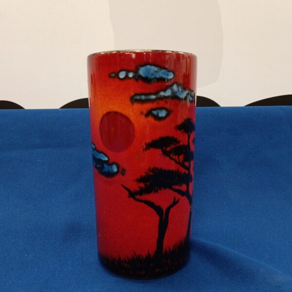 Front view of a vibrant Poole Pottery rising sun brush pot.