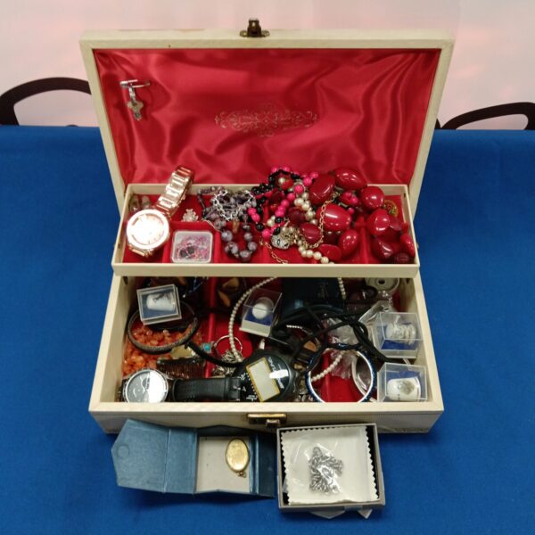 Mixed jewellery, watches, and thimbles in a display box.