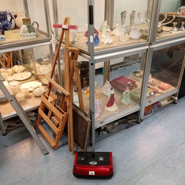 Vintage Ewbank carpet sweeper in a display cabinet.
