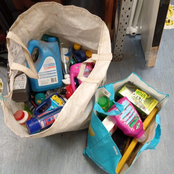 Mixed lot of cleaning chemicals in a large bag.