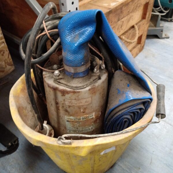 Vintage Tsurumi Star Baby submersible water pump with blue hose.