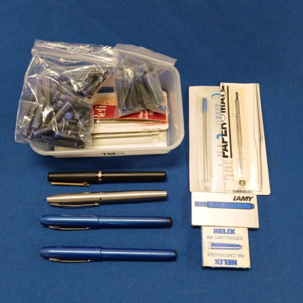 Mixed lot of fountain pens and ink refills for writing.