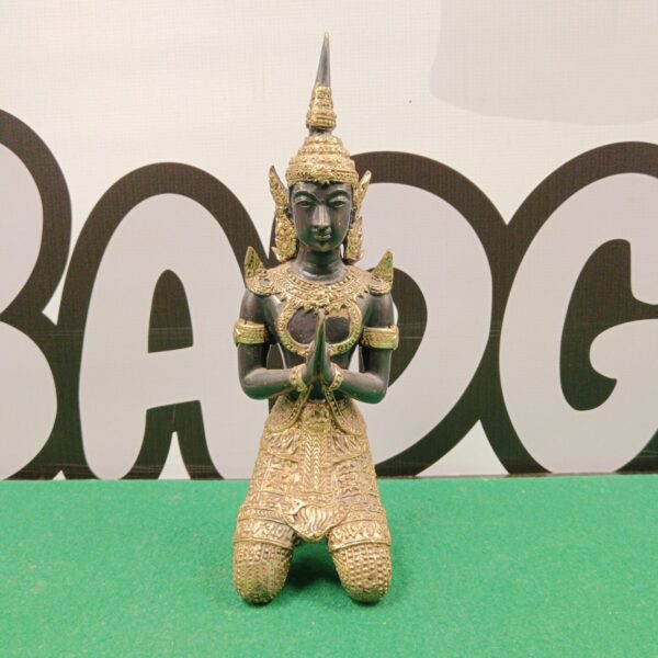 Intricate gilt bronze Buddha statue in kneeling posture.