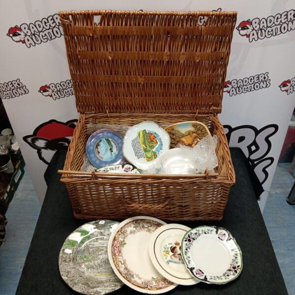 Wicker basket filled with a collection of vintage collectors plates.