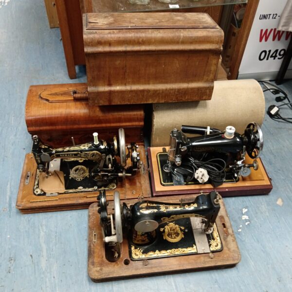Lot of three vintage sewing machines in cases.