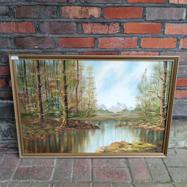 Signed oil painting of a tranquil woodland lake and mountains.