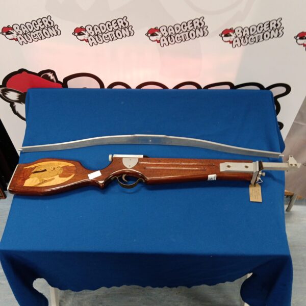 Vintage crossbow with detailed inlaid wooden stock, antique archery equipment.