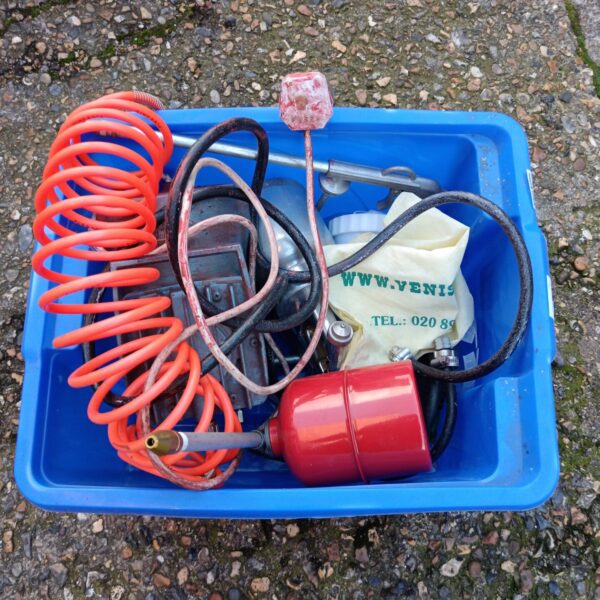 Vintage hobby air compressor and tools in blue tub.