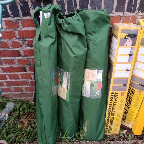 Three green folding camp beds stacked together.