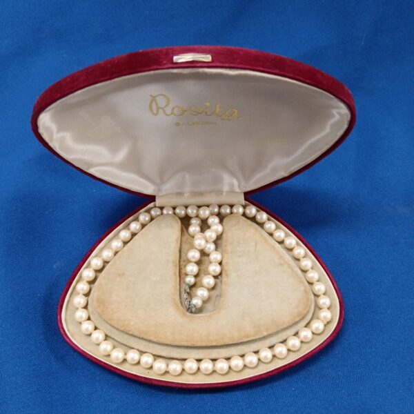 Vintage faux pearl necklace displayed in a presentation case.
