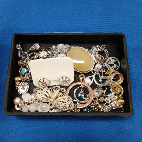 Tray of mixed jewellery including silver earrings and vintage brooches.