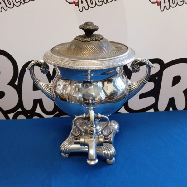 Antique silver plate tea urn with ornate detailing.