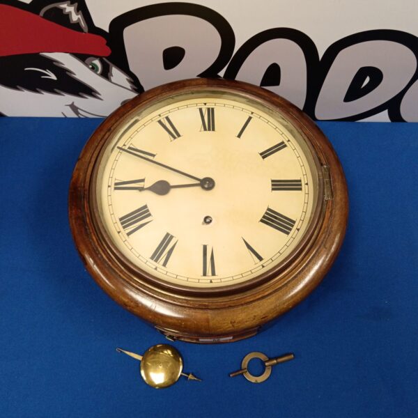 Antique wall clock with oak case and Roman numeral dial.