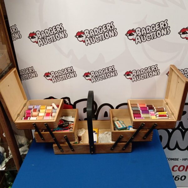 Vintage cantilever sewing box with colourful threads and ribbons.