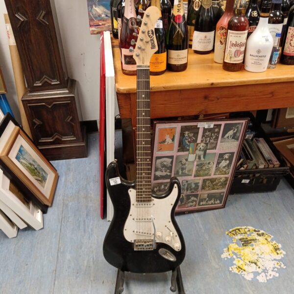 Vintage electric guitar displayed with bottles in background.