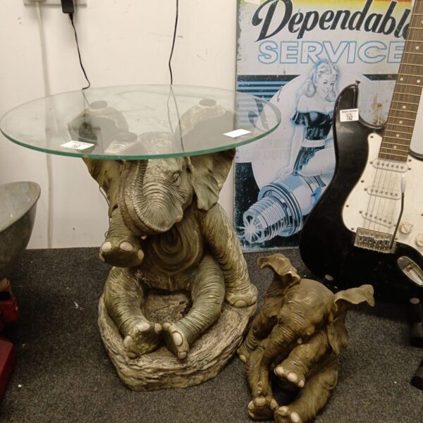 Detailed resin elephant wine table with glass top for home decor.