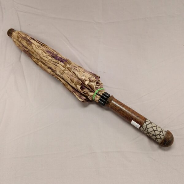 Vintage ladies umbrella with a patterned canopy and wooden handle.