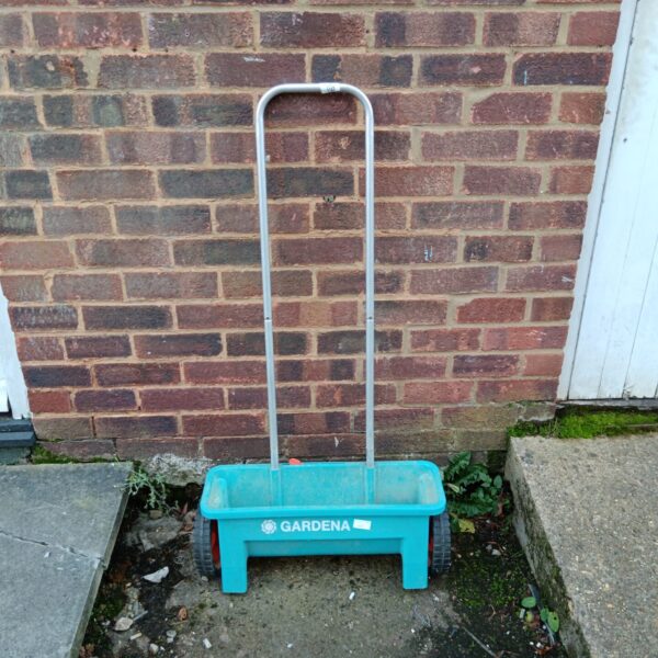 Green Gardena seed spreader for garden use.