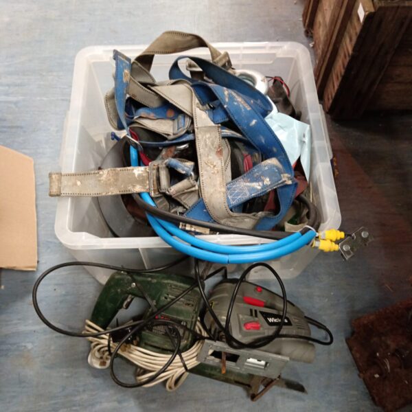Assorted power tools and straps in a plastic container.