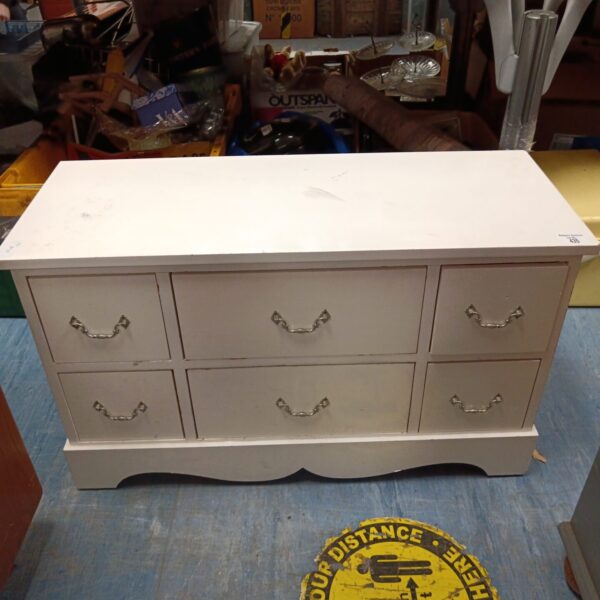 Small white six-drawer cabinet for bedroom storage.