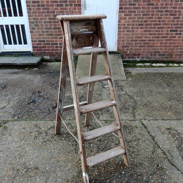 Vintage five-rung wooden step ladder, showing signs of age.