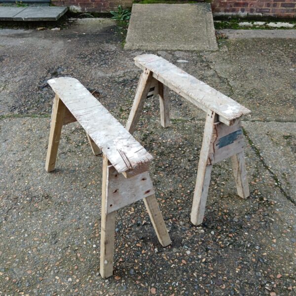 Pair of vintage wooden carpenters tressels in a garden setting.