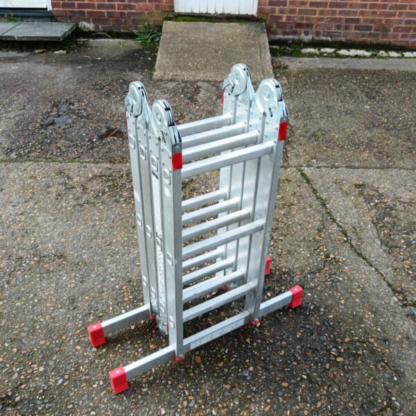 Silver three-way folding aluminium ladder against a brick wall.