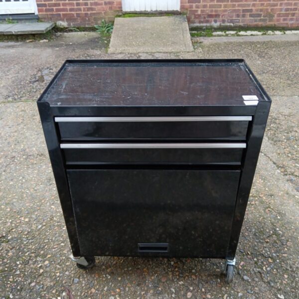 Black metal tool cabinet on wheels for workshop storage.