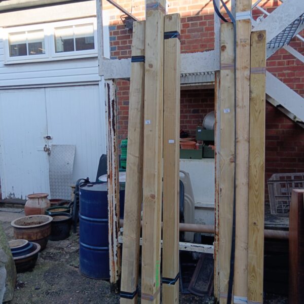 Bundles of softwood timber stored outdoors, ready for construction.