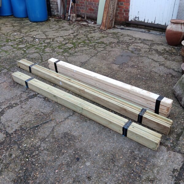 Bundles of softwood timber stored outdoors, ready for building projects.