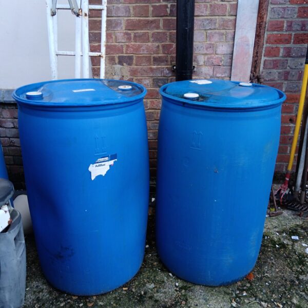 Two large blue plastic barrels for storage and garden use.