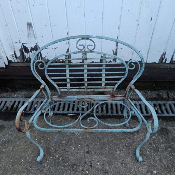 Vintage metal garden bench and plant stand in a weathered condition.