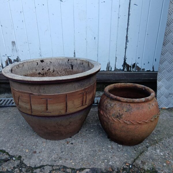 Vintage terracotta planter with Roman numeral design for garden decor.