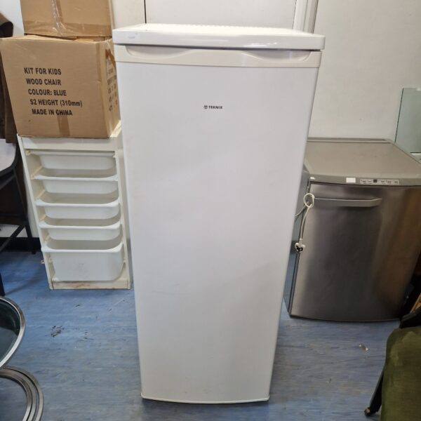 White Teknix freezer with boxes and storage nearby.