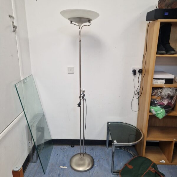 Chrome standard lamp with uplighter shade in a room setting.