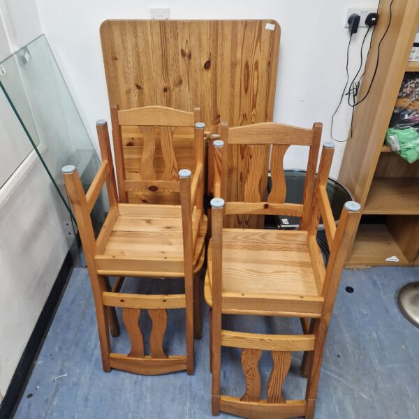 Rustic pine dining table with four matching chairs.