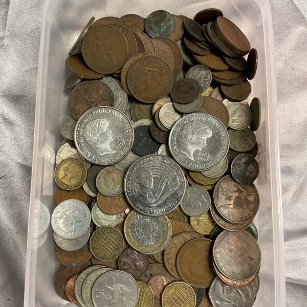 Assorted UK coins including £5 coins in a tray.