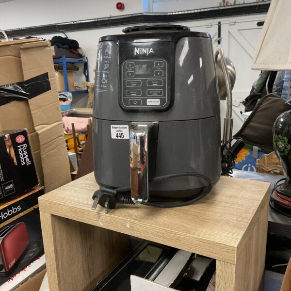 Black Ninja air fryer on a countertop, kitchen appliance.