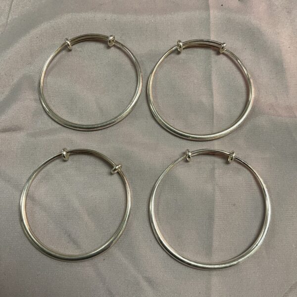 Set of four silver tone bangles, minimalist fashion jewelry.